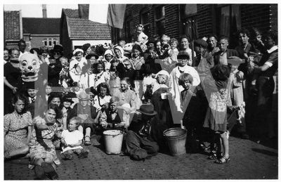 Bevrijdings-Straatfeest 1945-1946. Tuinstraat/Goudastraat.
Vooraan links: Miep Pool en Dea van Leeuwen, daarachter Piet van Nieuwburg, Corrie van Leeuwen, Corry Wortel, Annie Wortel.
2e rij met hoed en witte kousen: Dik Boot, daarnaast met met hoed en pijp Tini Boot.
Vooraan achter witte emmer: Klaas Stuurman, daarachter mevrouw Koeman en mevrouw Krom daarnaast met hoofd schuin Piet ? van Leeuwen.
Vooraan staand 2 meiskes van Apeldoorn.
Rechts met pet Klaas Kwadijk daarboven Niek Wortel daarnaast mevrouw Bootsman.
Midden jongen met bril Ot van Leeuwen, met witte capuchon Trien van Wijngaarden, meisje met witte jurk en bloemenslinger Gré Kan daarnaast Tonni Visser met witte muts Dick Visser en Tini van Leeuwen
Trefwoorden: Bevrijdings-Straatfeest 1945-1946 Tuinstraat/Goudastraat Miep Pool Dea van Leeuwen Piet van Nieuwburg Corrie van Leeuwen Corry Wortel Annie Wortel Dik Boot Tini Boot Klaas Stuurman mevrouw Koeman mevrouw Krom Piet ? van Leeuwen 2 meiskes van Apeldoorn Kla